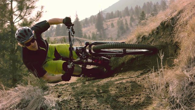 Mountain Biker Takes a Sharp Turn in parallel to the Ground