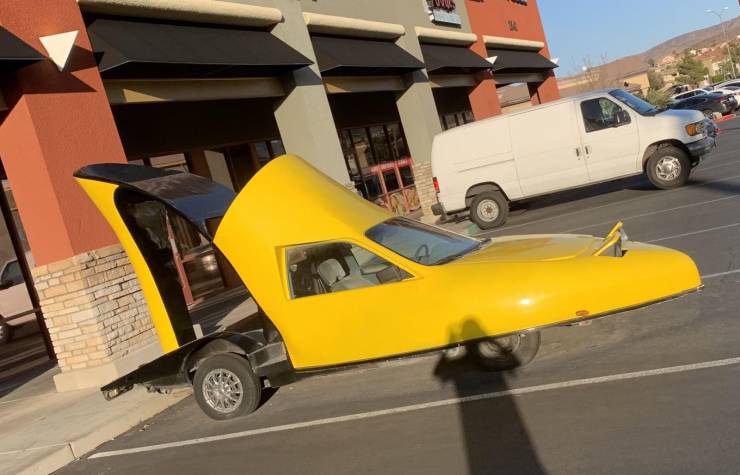 There is a yellow car in the parking lot, made in the form of a woman high-heeled shoe.