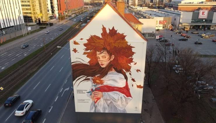 A beautiful mural depicting a woman in a white tunic with a hat made of maple leaves.