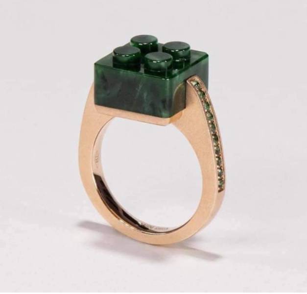 A golden ring with a jewel made in the form of a lego block.