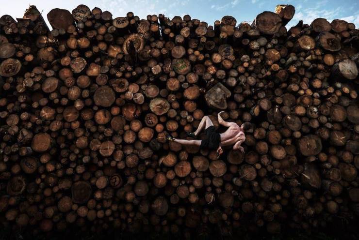 The horizontal projection of a man lying on wooden logs.