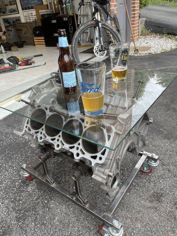 A glass cocktail table made of engine equipment.