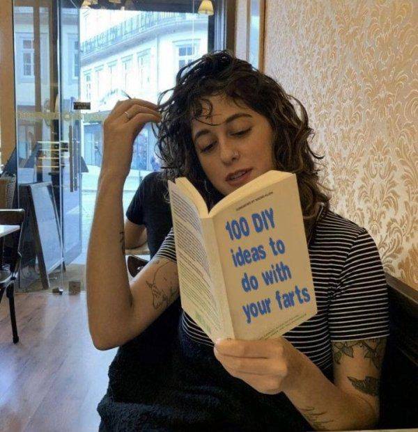 A girl in a cafe reading the book:" 100 DIY ideas to do with your farts."