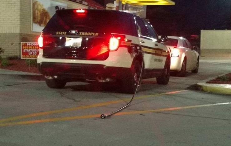 A police car with a petrol gun hanging from it.