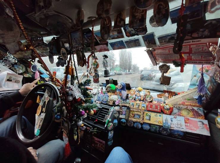 A driver seat decorated with a huge amount of souvenirs and matroshkas.