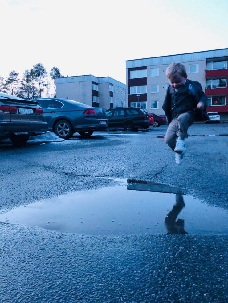 A kid who is about to jump into the puddle.