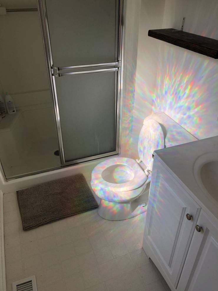 A toilet bowl shining in the rainbow light.