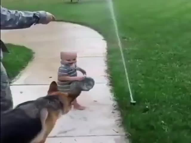 A Toddler Shows His Friend That Theres No Need To Be Afraid Of The Sprinkler