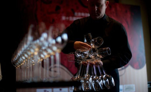 Wine Expert Sets World Record for Holding Wine Glasses!