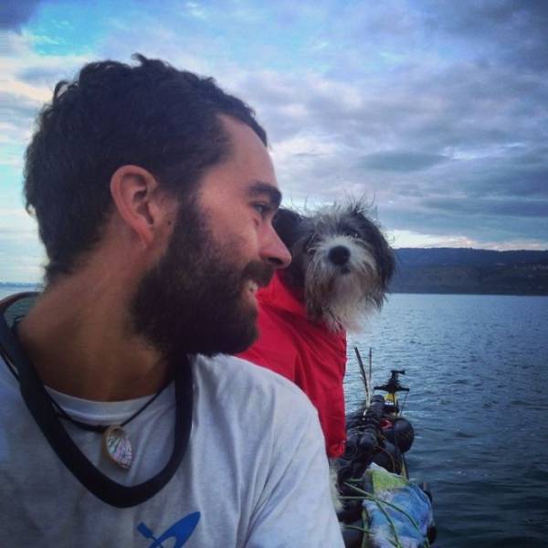 Man Kayaking The Sea With A Dog He Found On The Way